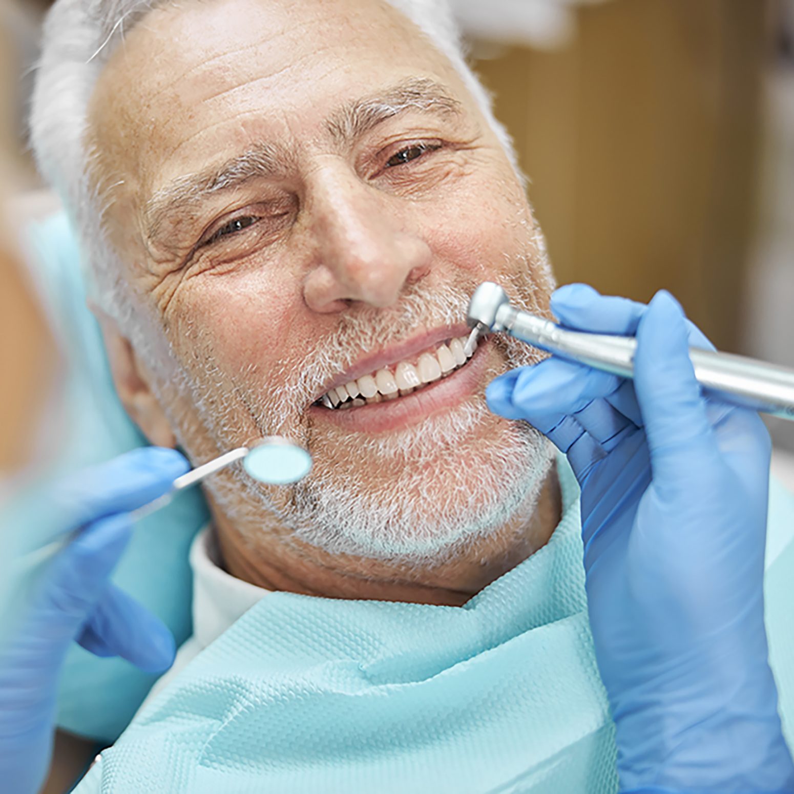 Close-up photo of a cheerful aged man smiling while having his teeth checked for caries and cavities